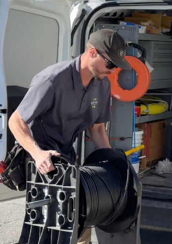 UTOPIA Fiber installer takes equipment out of back of van