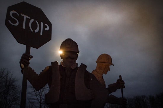 A construction stands holding a stop sign