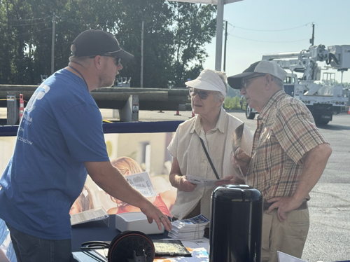 Paulding Putnam Electric Cooperative employee and elderly couple A Paulding Putnam Electric Cooperative speaks with an elderly couple about the co-ops new fiber Internet offering at a table outside