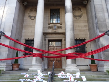A government building entrance is blocked with red tape