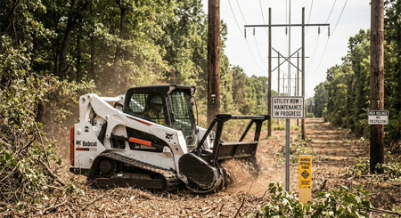 A tractor clears brush in a public right of way under power lines
