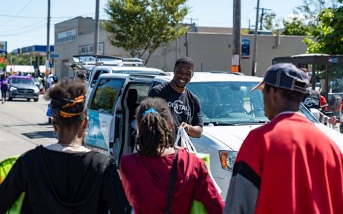 DigitalC CEO Josh Edmonds at community event meeting with several neighborhood residents with a smile
