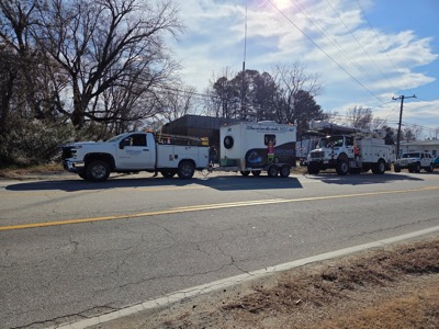 Two Empower Broadband service trucks parked along side of the street under utility wires